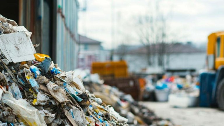 Açık alanda atık yığını ve arkada kamyon – Atık Kodları